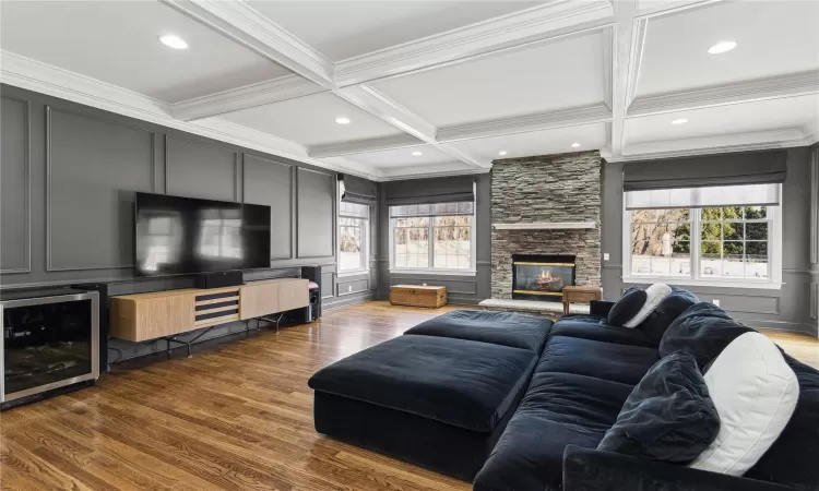 Living room featuring a fireplace, beam ceiling, dark hardwood / wood-style floors, and wine cooler