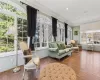 Sitting room with wood-type flooring and crown molding