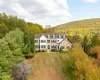 View of front of home with a mountain view and a front lawn