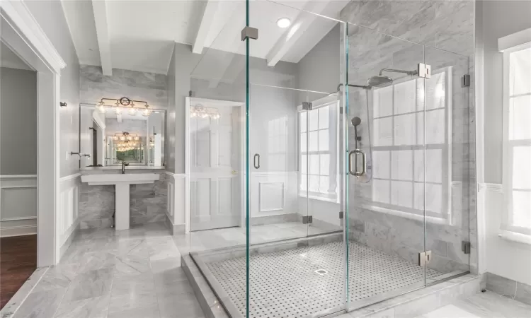 Bathroom with beamed ceiling and a shower with door