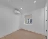 Spare room with a wall mounted AC and light hardwood / wood-style floors