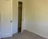 Unfurnished bedroom with light carpet and a closet