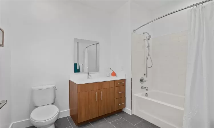 Full bathroom with vanity, tile patterned floors, toilet, and shower / tub combo