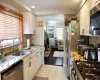 Kitchen with white cabinetry, decorative backsplash, sink, and stainless steel appliances