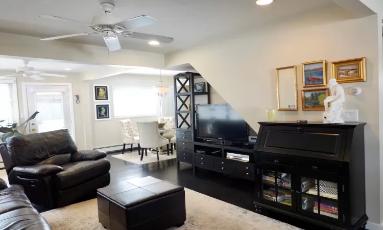 Living room with sofas, ceiling fan, and hardwood / wood-style flooring