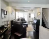 Living room with ceiling fan, dark wood-type flooring