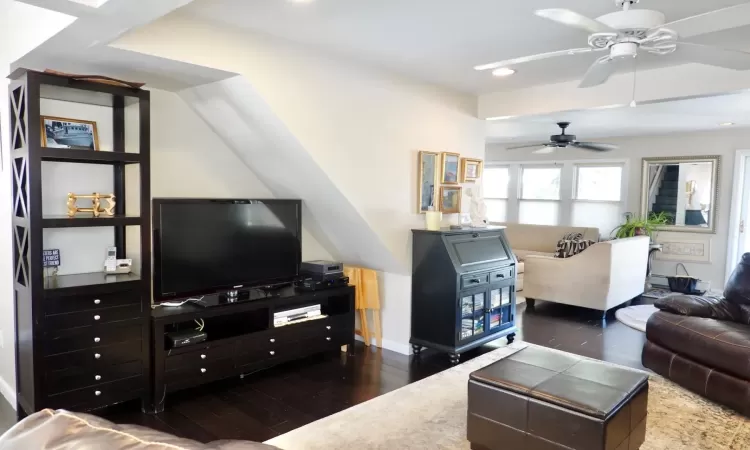 Living room with dark hardwood / wood-style floors and ceiling fan