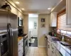 Kitchen featuring stainless steel appliances and white cabinetry