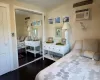 Bedroom featuring a wall mounted air conditioner, wood-type flooring, and a closet