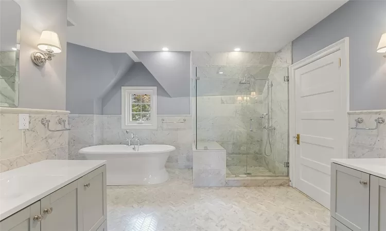 Bathroom featuring vanity, tile walls, and independent shower and bath