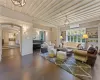 Living room with a wall mounted air conditioner, dark parquet floors, and a chandelier