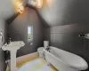 Bathroom featuring toilet, lofted ceiling, and a tub to relax in