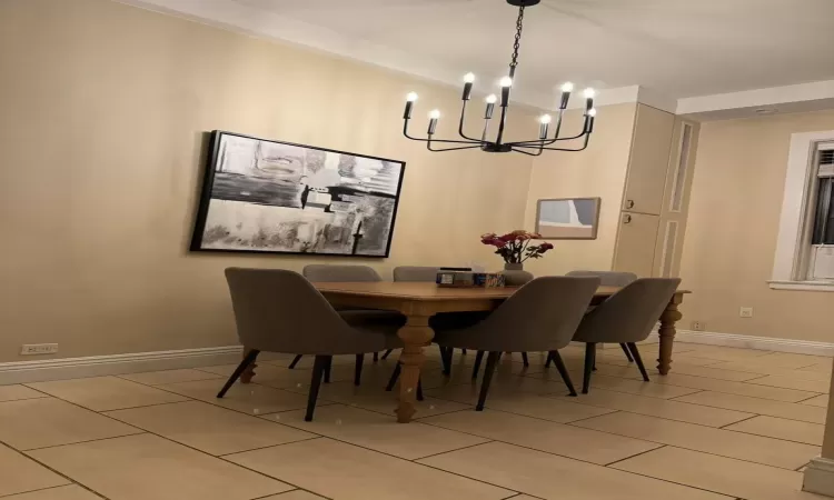 Dining space featuring beamed ceiling and an inviting chandelier