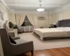 Bedroom featuring beam ceiling, radiator heating unit, hardwood / wood-style floors, and a wall mounted air conditioner