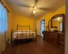 Bedroom with ceiling fan, dark hardwood / wood-style floors, and crown molding