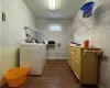 Clothes washing area with separate washer and dryer and dark wood-type flooring