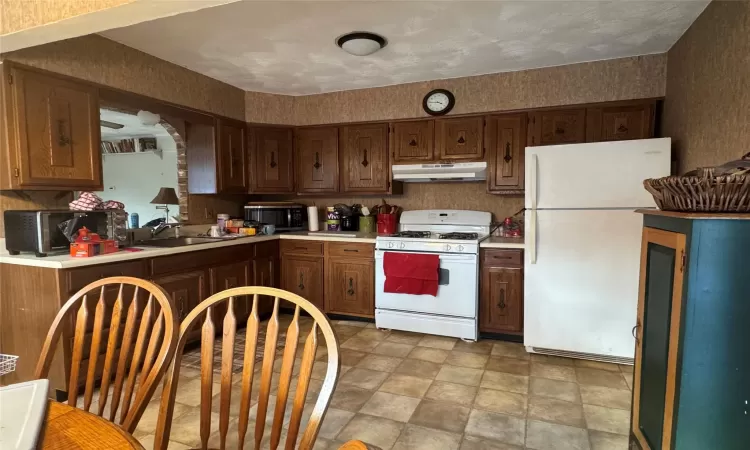 Kitchen with white appliances and sink