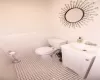 Bathroom with tile patterned floors, vanity, tile walls, and toilet