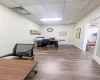 Office area with a drop ceiling and wood-type flooring