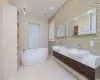 Bathroom with backsplash, a tub to relax in, and sink