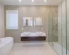 Bathroom featuring vanity, tile walls, plus walk in shower, and tasteful backsplash