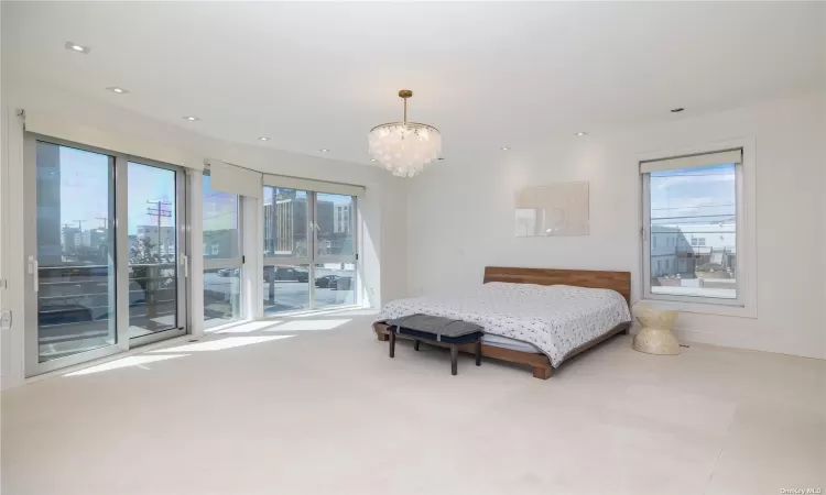 Bedroom featuring a notable chandelier and access to outside