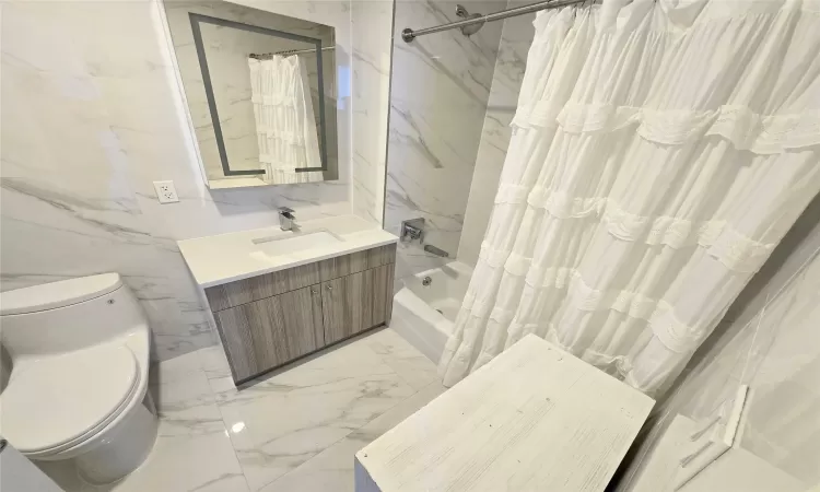 Full bathroom with vanity, toilet, and shower / bathtub combination with curtain