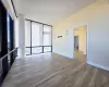 Unfurnished room with floor to ceiling windows and wood-type flooring