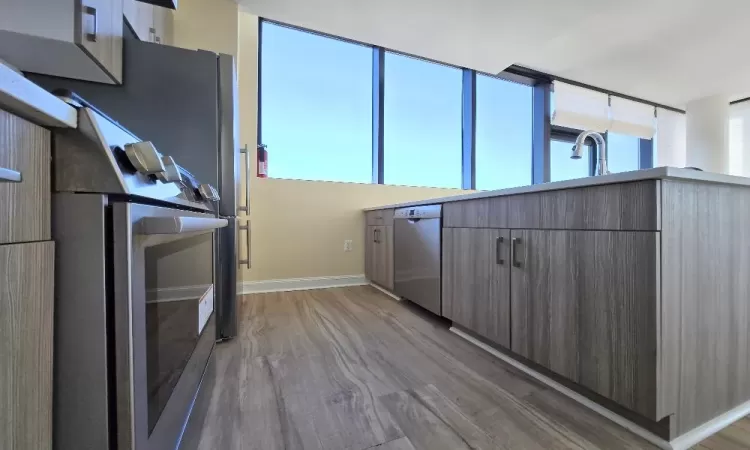 Kitchen with sink, dishwasher, refrigerator, and light wood-type flooring