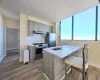 Kitchen featuring sink, stainless steel appliances, light hardwood / wood-style floors, a breakfast bar, and exhaust hood