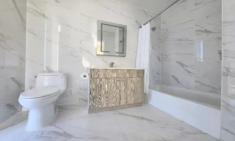 Full bathroom with shower / tub combo with curtain, vanity, and toilet