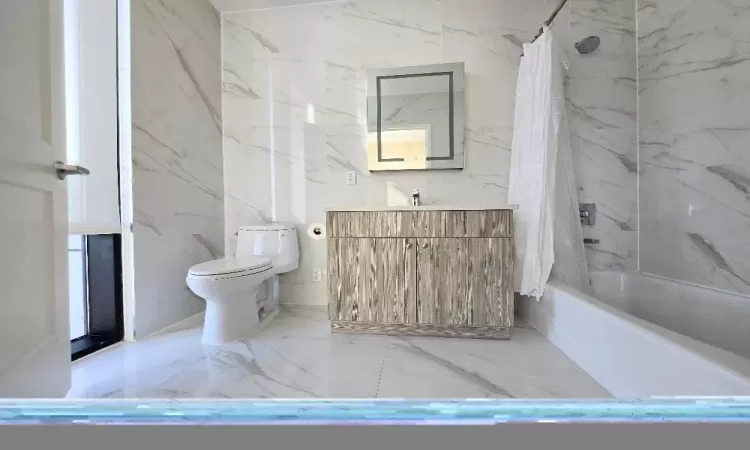 Full bathroom featuring shower / bath combination with curtain, vanity, and toilet