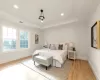 Bedroom with a tray ceiling, light oak wood flooring