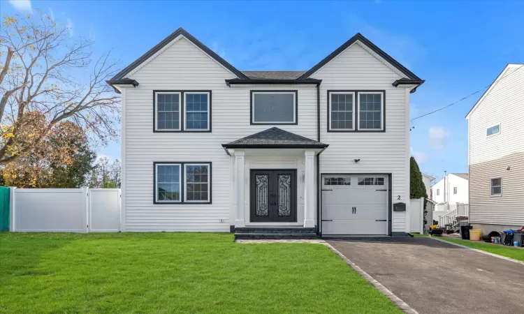 View of front of house with iron doors, a garage