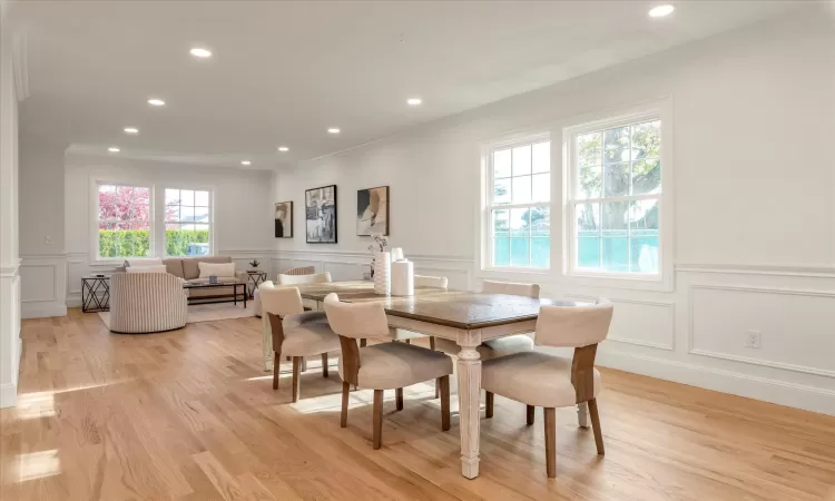 Dining area with crown molding and light oak wood floors