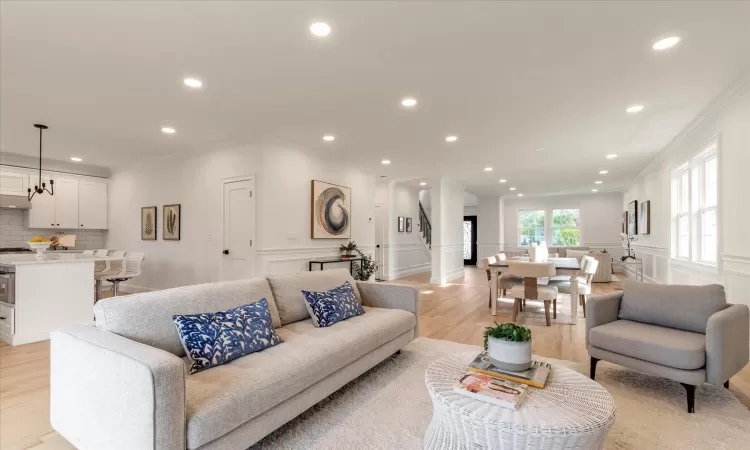 Den featuring crown molding and light oak wood floors