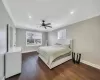 Bedroom with ceiling fan, dark wood-type flooring, and ornamental molding