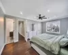 Bedroom with ceiling fan, dark hardwood / wood-style floors, crown molding, and ensuite bath