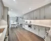 Kitchen featuring stainless steel refrigerator, gray cabinetry, tasteful backsplash, and dark hardwood / wood-style floors