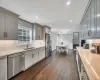 Kitchen with appliances with stainless steel finishes, dark hardwood / wood-style flooring, gray cabinetry, and sink