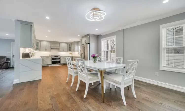 Dining space with crown molding and dark hardwood / wood-style flooring