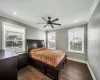 Bedroom with ceiling fan, crown molding, and dark wood-type flooring