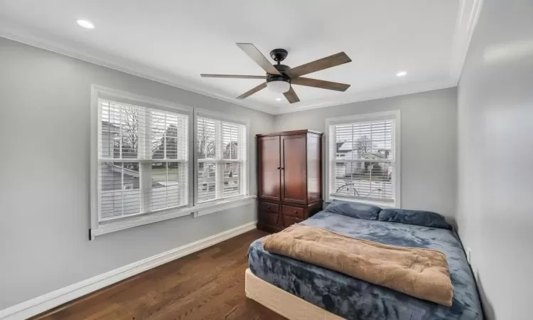 Bedroom featuring ornamental molding, ceiling fan, and dark wood-type flooring