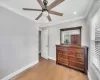 Bedroom featuring ceiling fan, light wood-type flooring, and ornamental molding