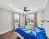 Bedroom with multiple windows, ceiling fan, dark hardwood / wood-style flooring, and ornamental molding