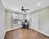 Office area with ceiling fan, dark wood-type flooring, and ornamental molding