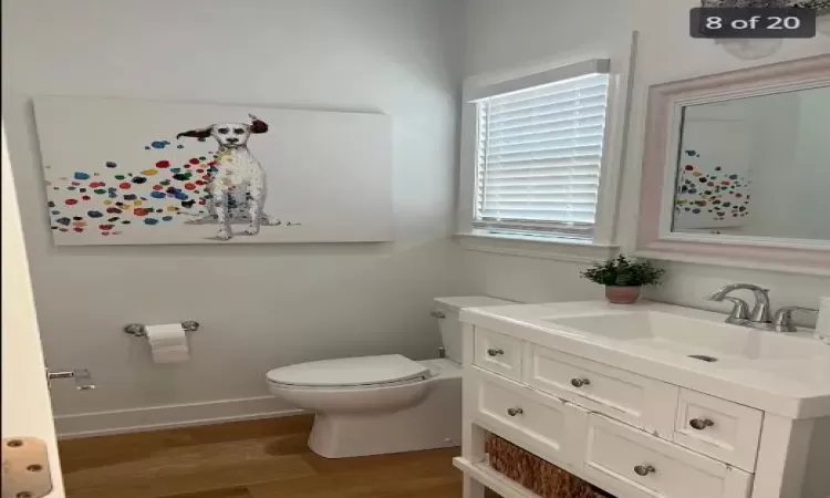 Bathroom with vanity, hardwood / wood-style flooring, and toilet