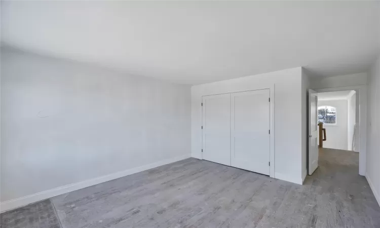 Unfurnished bedroom with light hardwood / wood-style floors and a closet