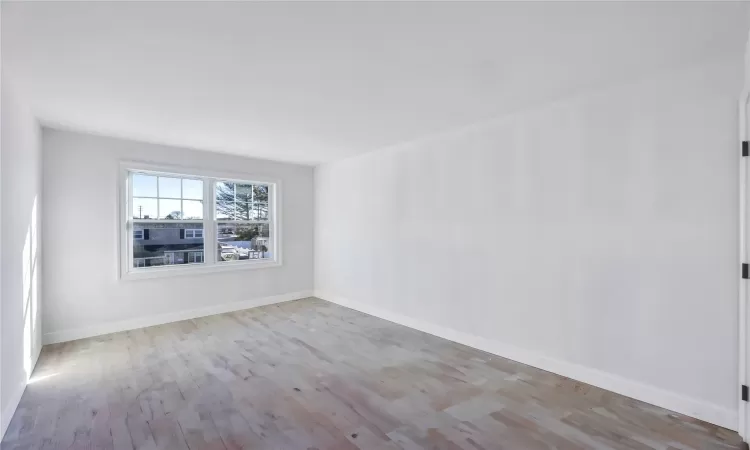 Empty room with light hardwood / wood-style flooring