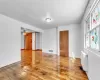 Empty room featuring ceiling fan, wood-type flooring, and radiator heating unit